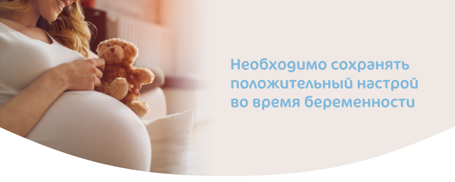 Беременная женщина улыбается и сохраняет положительный настрой